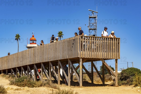 Tourists on the rocky coast of Ponta da Piedade, rugged coastal landscape, right next to Lagos city