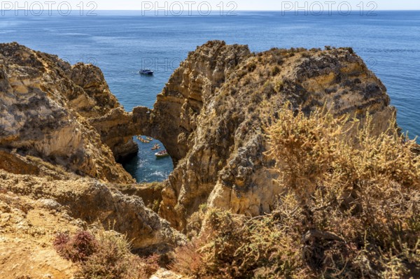 Crowds of excursion boats at the caves and rocky gates of the Ponta da Piedade rocky coast, rugged