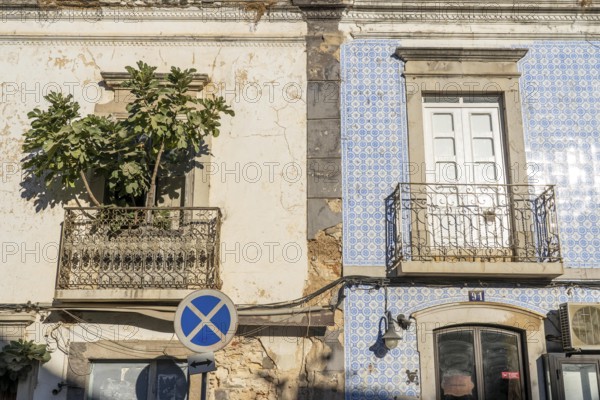 Facade of buildings decorated with tiles, azulejos, coloured tiles on facades, in Tavira, old town,