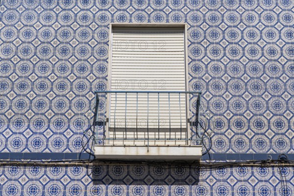Facade of buildings decorated with tiles, azulejos, coloured tiles on facades, in Tavira, old town,