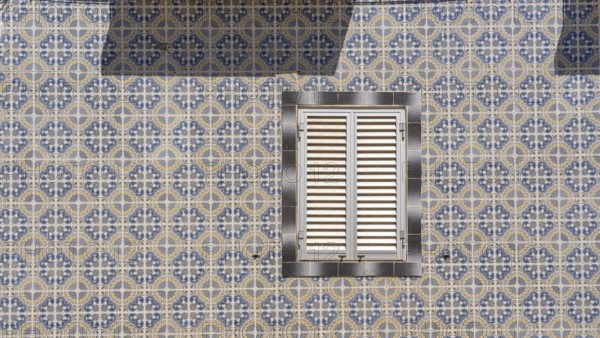 Facade of buildings decorated with tiles, azulejos, coloured tiles on facades, in Tavira, old town,