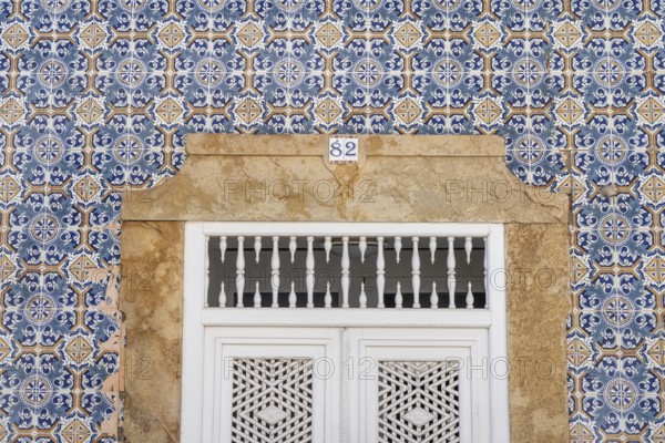 Facade of buildings decorated with tiles, azulejos, coloured tiles on facades, in Tavira, old town,