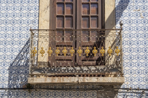 Facade of buildings decorated with tiles, azulejos, coloured tiles on facades, in Tavira, old town,