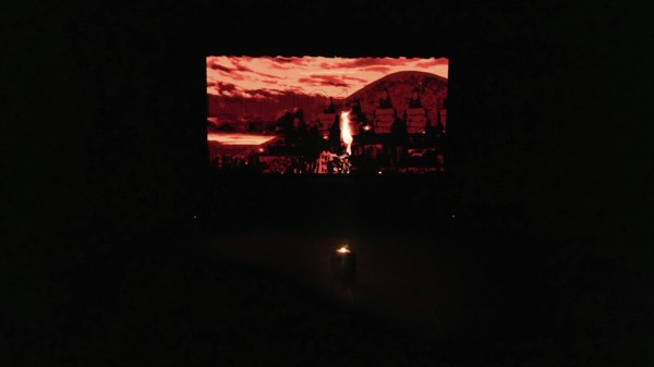 Dancers from Fire of Anatolia perform a choreography in red costumes with a historic stone wall