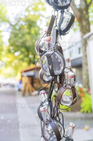 Leather-wrapped bottles hanging decoratively from a stall at a market, Sindelfingen, Böblingen