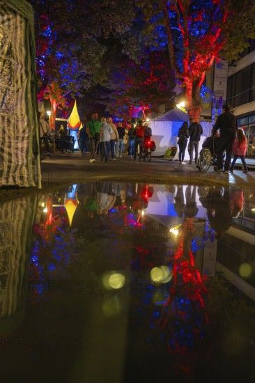 Colourful night lights reflected in a rain-soaked street during an event, Sindelfingen, Böblingen