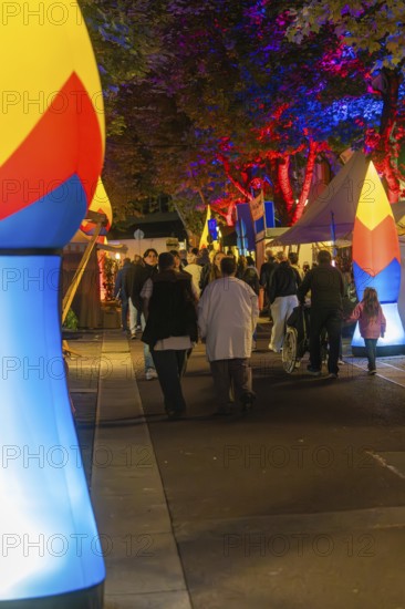People walking at night on a street illuminated with colourful lights, Sindelfingen, Böblingen