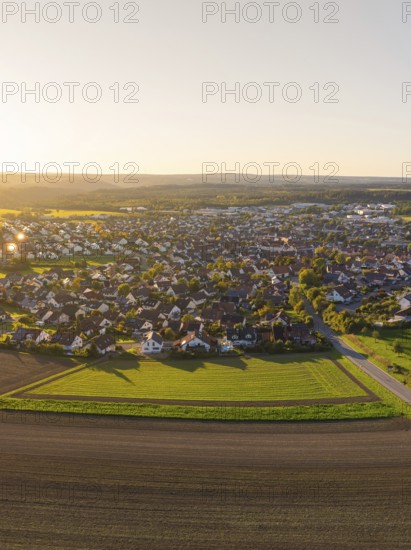 Aerial view of a village surrounded by fields at sunset with rural charm, Althengstett, district of