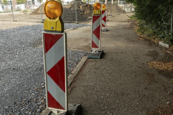 Borken, NRW, Germany, Red and white striped warning posts with flashing orange lights marking a