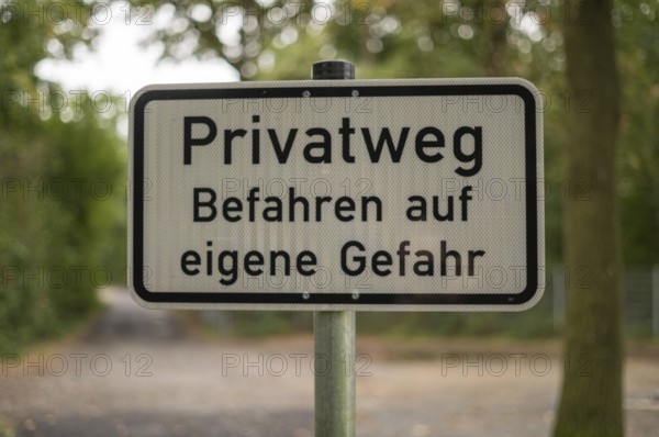 Borken, NRW, Germany, German warning sign privatweg befahren auf eigene gefahr on a pole in a