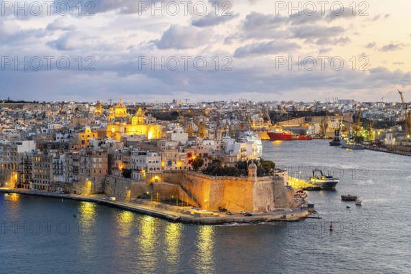 Beautiful evening view of illuminated Valletta, Birgu with Saint Angelo Fortress, capital city of
