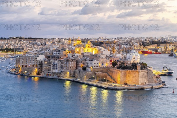 Beautiful evening view of illuminated Valletta, Birgu with Saint Angelo Fortress, capital city of