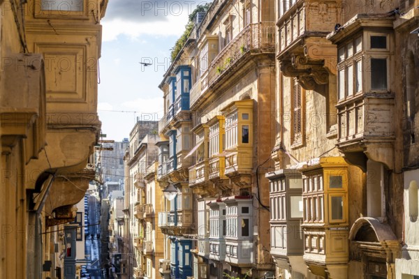 Street with amazing historic houses with colorful wooden balconies in La Valletta, capital city of