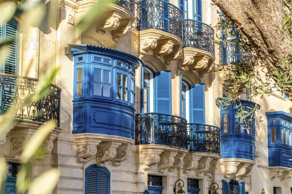 Street with amazing historic houses with colorful wooden balconies in La Valletta, capital city of