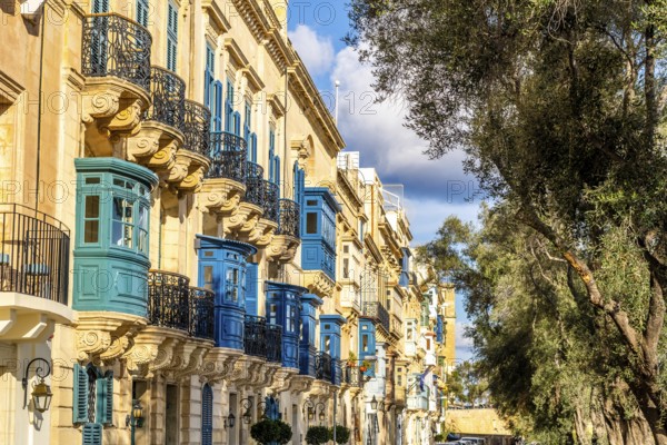 Street with amazing historic houses with colorful wooden balconies in La Valletta, capital city of