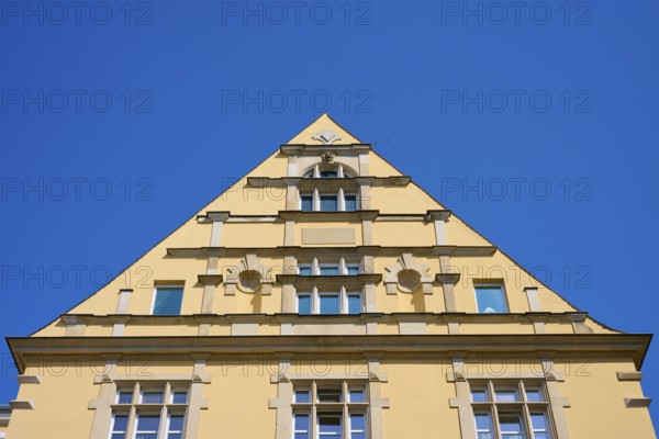 Building with striking triangular gable and windows against a clear sky, Regensburg, Bavaria,