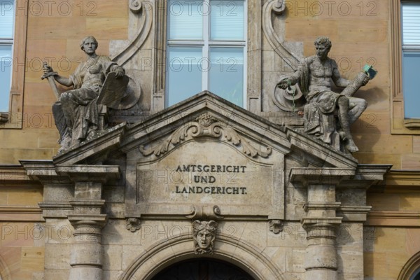 Historic façade of a court building with decorative sculptures and classical architecture, district