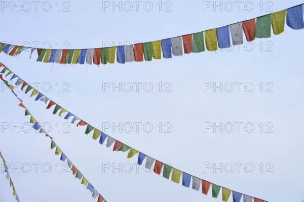 Colourful prayer flags flutter in the blue sky, conveying a feeling of freedom and peace, Bavaria,