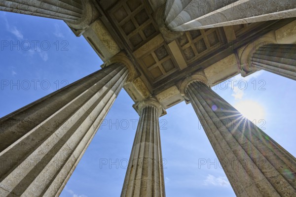 Imposing columns against a bright blue sky with a view of the sun, Walhalla, Donaustauf,