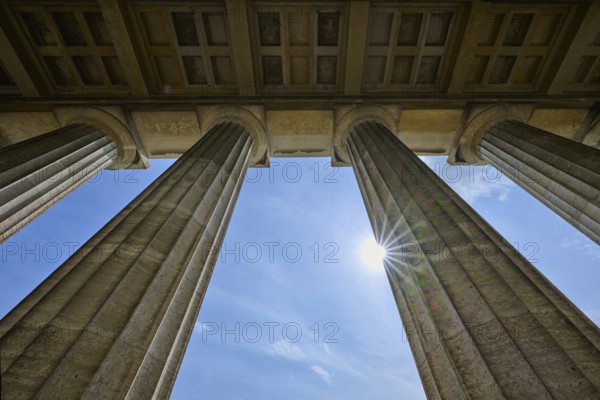 Classical stone pillars rise into the sky, pierced by rays of sunlight, Walhalla, Donaustauf,