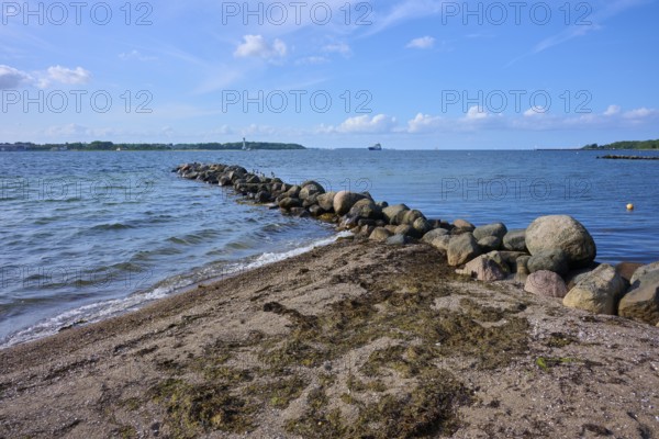 Stone breakwater in the sea on a sunny beach day with blue sky, Heikendorf, Plön district, Kiel