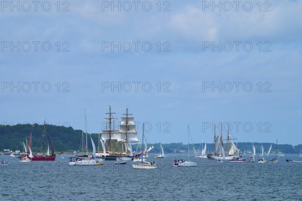 Numerous yachts and sailing ships sailing under a slightly cloudy sky, Windjammer Parade Kiel 2025,