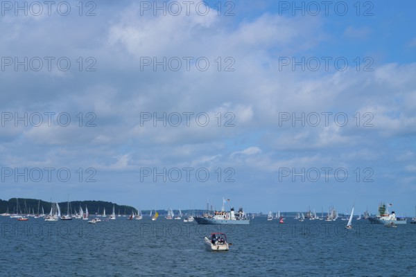 Scattered boats on the sea under a cloudy blue sky, wide visible, Windjammer Parade Kiel 2025,
