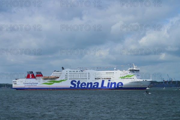 Stena Line ferry sails calmly across the sea under a dramatic, cloudy sky, Windjammer Parade Kiel