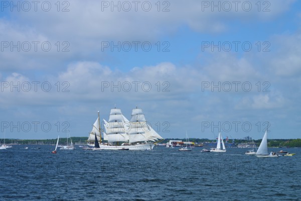 A magnificent tall ship Gorch Fock with white sails in a field of boats, Windjammer Parade Kiel