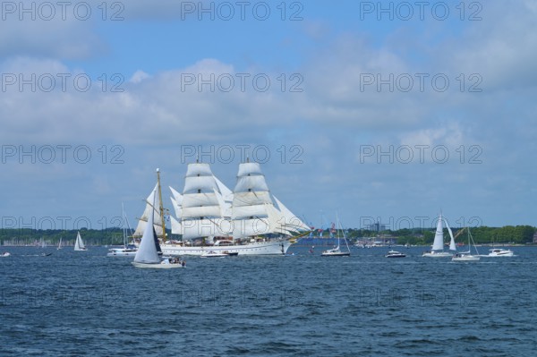 Tall ship Gorch Fock with white sails accompanied by small boats, Windjammer Parade Kiel 2025,