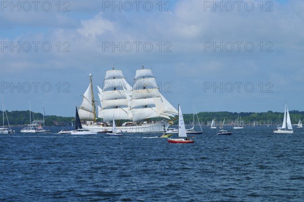 A tall ship Gorch Fock on the sea between several other boats, Windjammer Parade Kiel 2025,