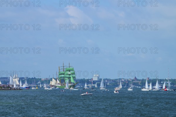 Green tall ship Alexander von Humbold 2 among many boats near a town, Windjammer Parade Kiel 2025,