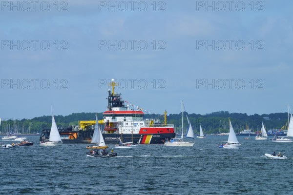 Various sailing boats and a large ship Arkona Coast Guard on a sunlit sea, Windjammer Parade Kiel