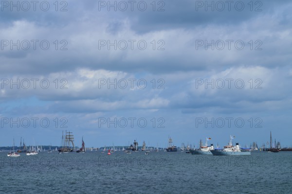 Yachts and sailing ships join each other on the sea under a cloudy sky, Windjammer Parade Kiel