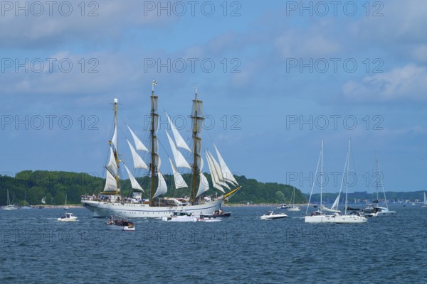 An impressive tall ship Gorch Fock with other boats on a sunny sea, Windjammer Parade Kiel 2025,