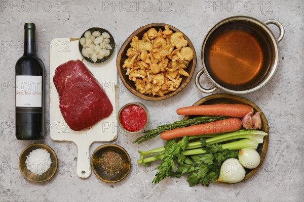 Fresh vegetables and tender beef are arranged on a kitchen counter, preparing for a delicious stew.