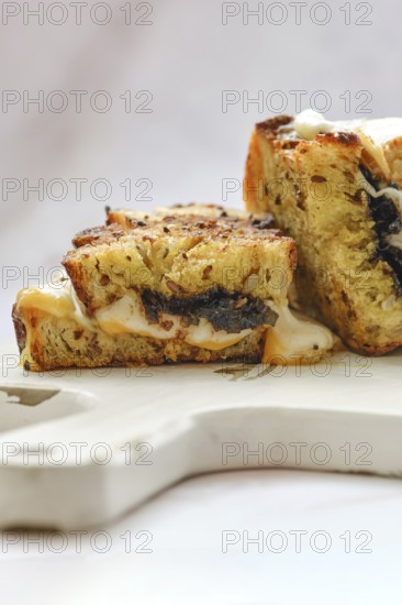 Melted cheese oozes from the sides of a perfectly toasted three cheese sandwich, showcasing a