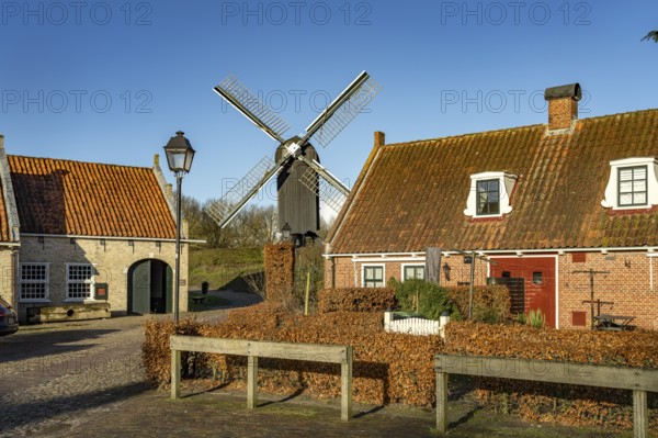 Traditional houses and windmill of the inhabited former fortress of Bourtange, Groningen,