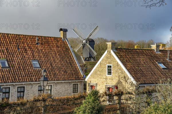Traditional houses and windmill of the inhabited former fortress of Bourtange, Groningen,
