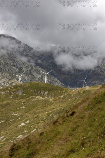 Wind turbines on the Gotthard Pass in the clouds, view from Passo Scimfuss, Airolo, Ticino,