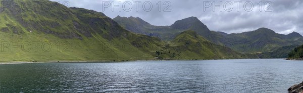 Lago Ritom panorama, right Passo del Sole and Passo dell'Uomo, left road on the lakeshore, Airolo,
