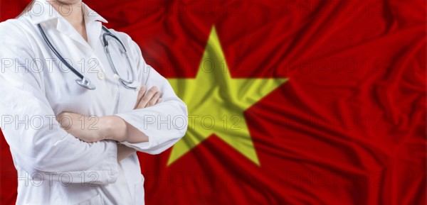 Doctor with crossed arms on Vietnam flag. Vietnam health and care concept. Female doctor on Vietnam