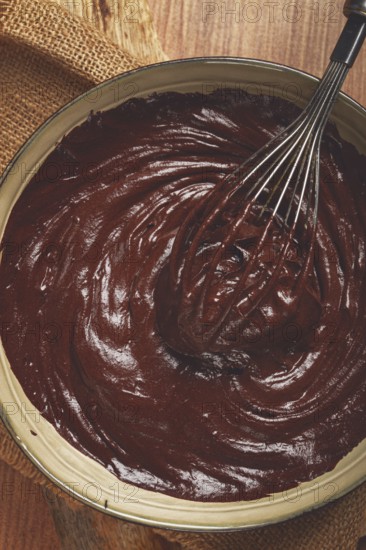 A bowl of chocolate dough, a whisk for whipping, baking, structure and consistency, homemade, top