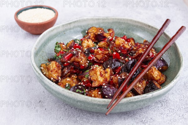 Fried eggplant, Chinese style, in sweet and sour sauce, with pepper and sesame seeds, in a green