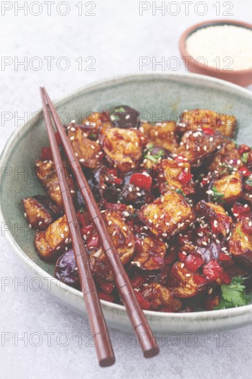 Fried eggplant, Chinese style, in sweet and sour sauce, with pepper and sesame seeds, in a green