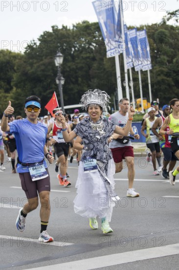 A runner with the flag of the People's Republic of China on the Great Star at the 51st BMW Berlin