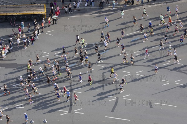 Runners with long shadows on the big star seen from the Victory Column at the 51st BMW Berlin