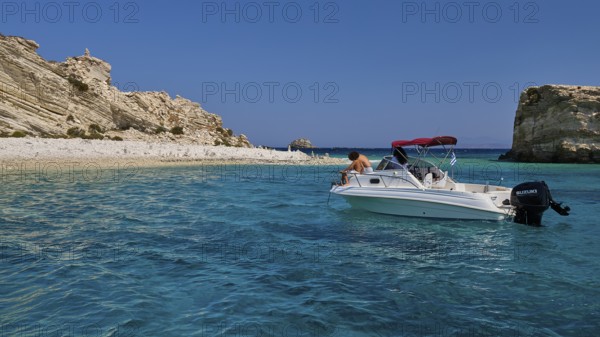 Motorboat drifting in the clear blue sea in front of a rocky coastline, White Cliffs, White Beach,