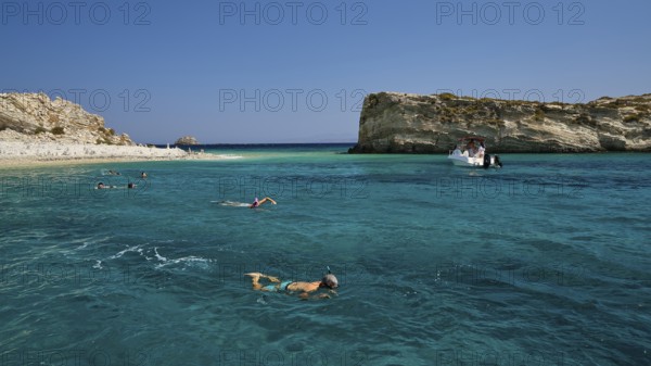 People swimming in the open sea, a boat approaches the rocks, White Cliffs, White Beach, Makri