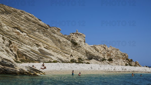 Rocky coast with people walking along the beach and swimming in the sea, White Cliffs, White Beach,